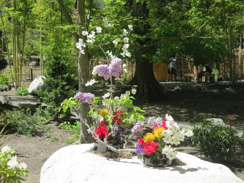 Flower arrangement on a wide granite rock with trees in the background